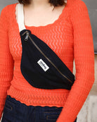 a woman wearing a red sweater and a black tie 