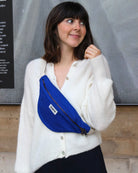 a woman in a white dress holding a blue suitcase 