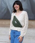 a woman standing on a sidewalk holding a cell phone 