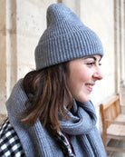 a young girl wearing a hat sitting on a bench 