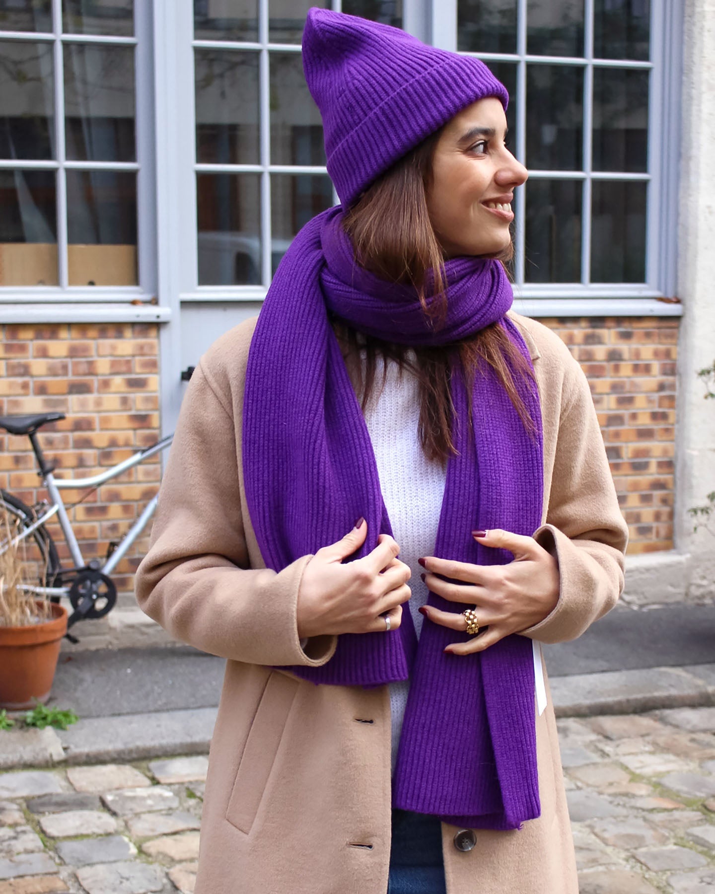 a woman in a purple dress talking on a cell phone 