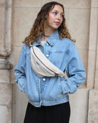 a woman in a blue jacket holding a suitcase 