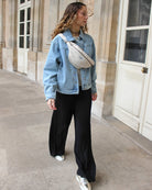 a woman is standing on a sidewalk talking on a cell phone 