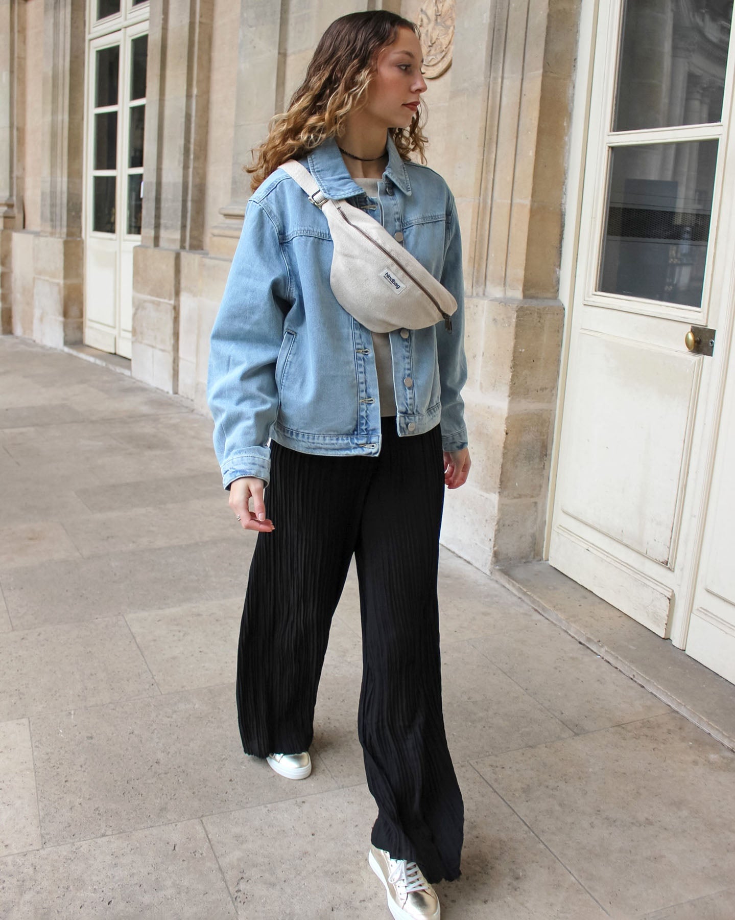 a woman is standing on a sidewalk talking on a cell phone 